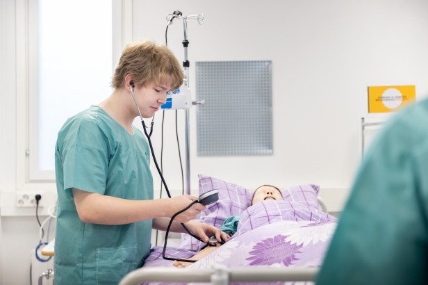 Samu harjoittelemassa verenpaineen mittausta.